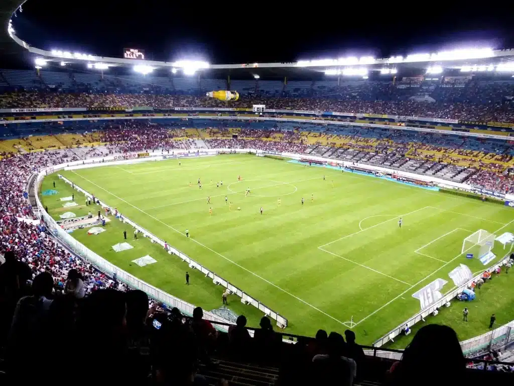 Une salle de sport comble lors d'un match de cécifoot, spectateurs enthousiastes dans les tribunes