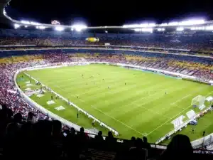 Une salle de sport comble lors d'un match de cécifoot, spectateurs enthousiastes dans les tribunes
