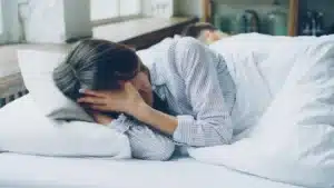 Chambre fraîche avec stores fermés, verre d'eau et literie légère pour se protéger de la chaleur