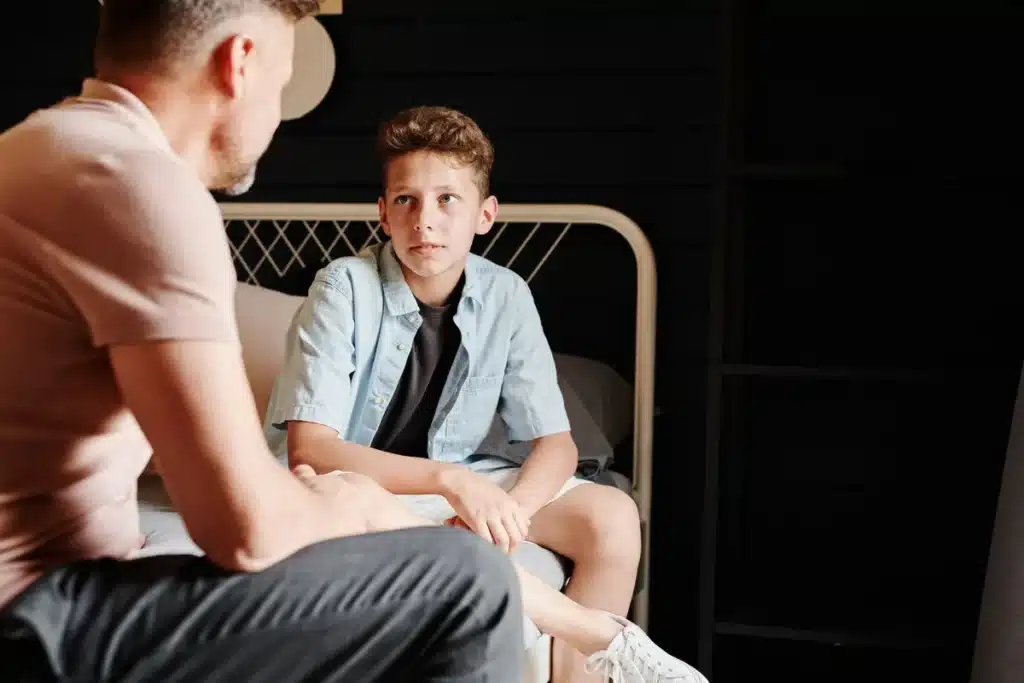 Parent et enfant en discussion sérieuse à table, illustrant un moment de négociation et de limites