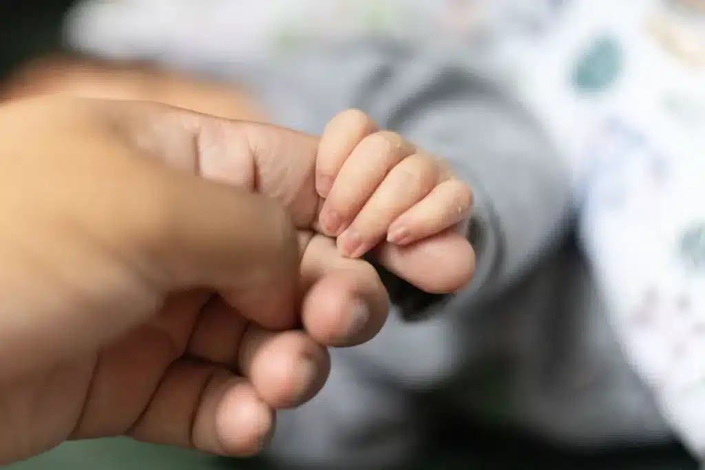 Main d'un enfant se tournant vers un adulte dans un moment de sécurité et de calme