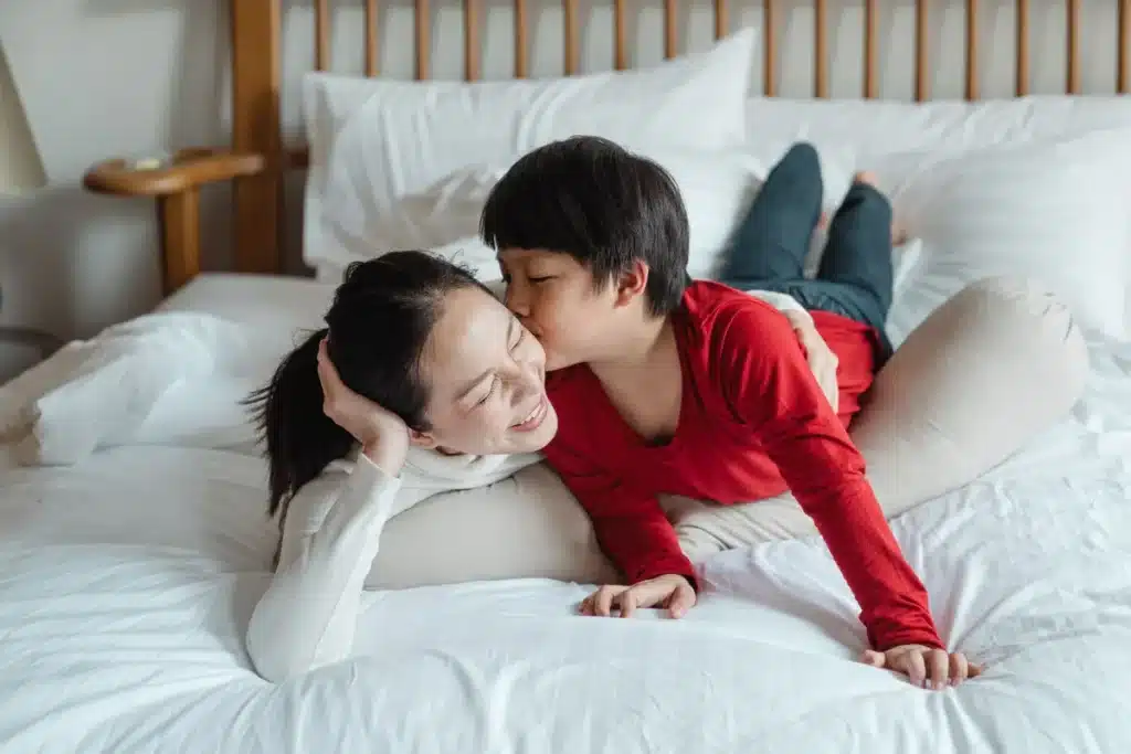 Parent en pause silencieuse, tête baissée, lumière douce du matin, moment de calme et de récupération mentale.