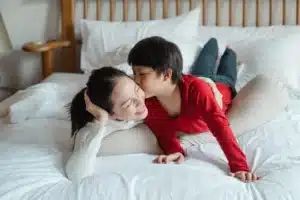 Parent en pause silencieuse, tête baissée, lumière douce du matin, moment de calme et de récupération mentale.