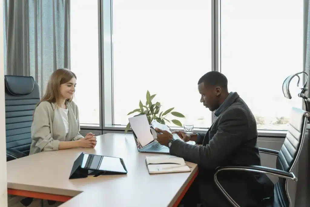 Équipe diverse en réunion autour d'un bureau avec documents de recrutement et accessibilité