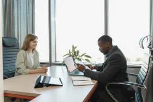 Équipe diverse en réunion autour d'un bureau avec documents de recrutement et accessibilité