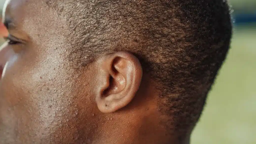 Personne plaçant sa main derrière l'oreille pour mieux écouter dans un environnement calme