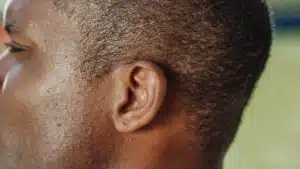 Personne plaçant sa main derrière l'oreille pour mieux écouter dans un environnement calme