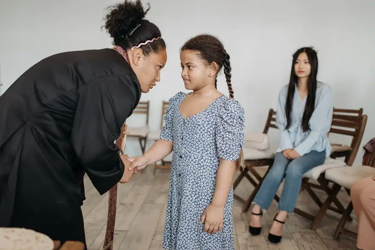 Un adulte et un enfant en conversation, l'adulte à la hauteur de l'enfant