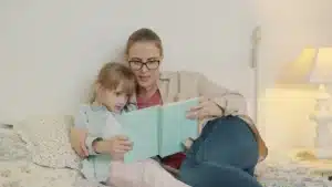 Un adulte s'accroupit à la hauteur d'un enfant pour lui parler avec attention