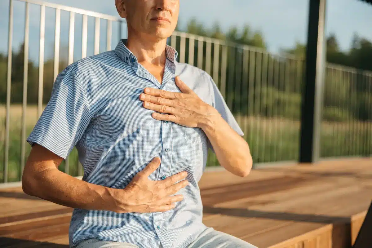 Personne observant les signaux de son corps : respiration, tension musculaire, signes physiques de stress