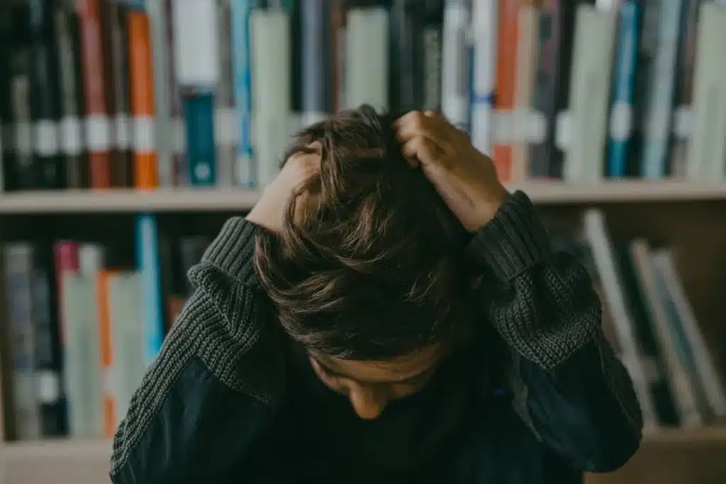 Mains crispées d'un parent sur une table, mâchoire tendue, moment de stress familial
