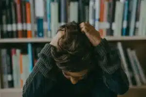 Mains crispées d'un parent sur une table, mâchoire tendue, moment de stress familial