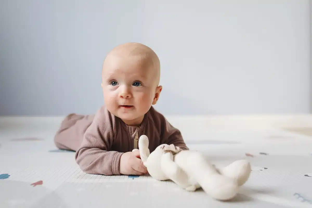 Bébé en motricité libre sur un tapis de mousse confortable