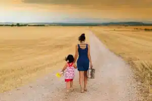 Parent et enfant en conversation calme, mains détendues, lumière douce et environnement bienveillant.
