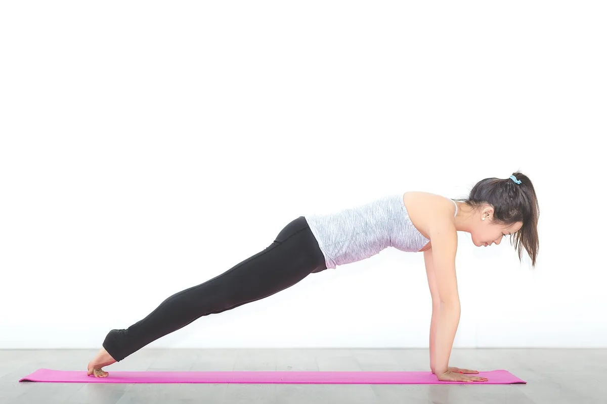 Personne pratiquant du yoga doux à la maison près d'une fenêtre