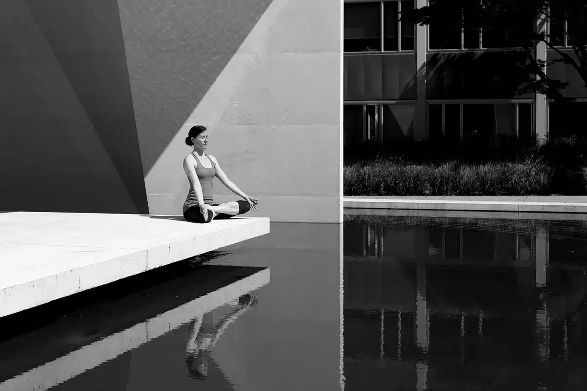 Femme en position de relaxation effectuant des exercices de respiration pour relâcher les tensions.