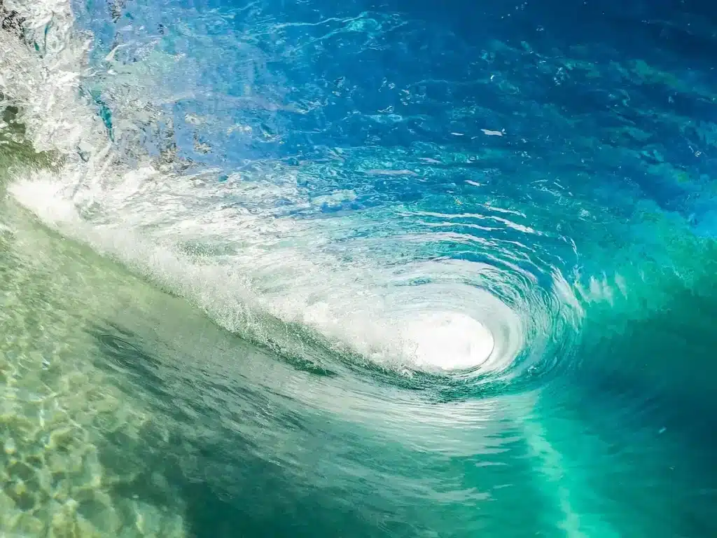 Écume blanche mousseuse recouvrant le rivage lors du ressac des vagues