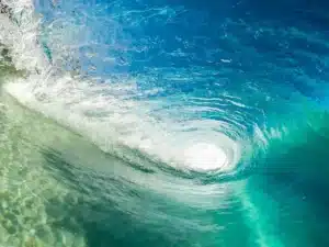 Écume blanche mousseuse recouvrant le rivage lors du ressac des vagues