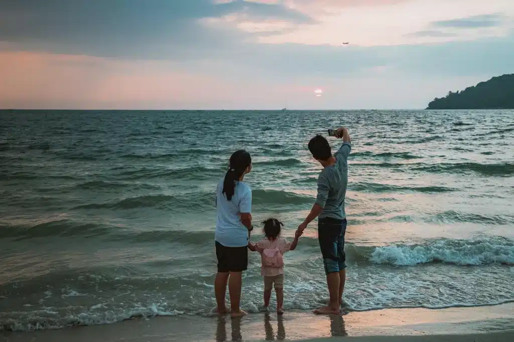 Parent et enfant discutant ensemble devant un téléphone, illustrant la conversation autour du premier mobile