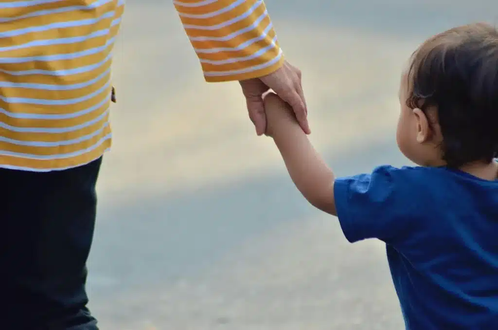 Un adulte et un enfant assis côte à côte dans une atmosphère apaisante, dans une posture de soutien bienveillant.