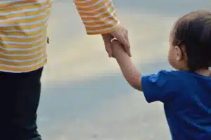Un adulte et un enfant assis côte à côte dans une atmosphère apaisante, dans une posture de soutien bienveillant.