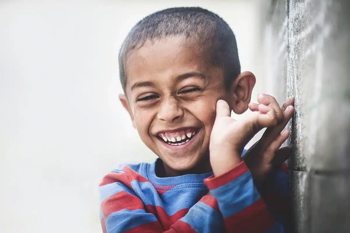 Enfant riant devant une scène de comédie visuelle