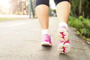 Paire de chaussures de course sur un banc de parc avec carnet d'entraînement en plein jour