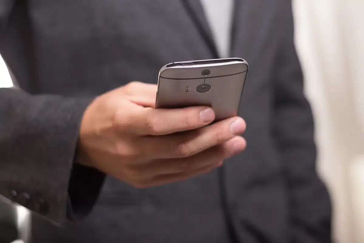 Téléphone posé sur une table avec un carnet et un stylo, rappel des numéros d'alerte