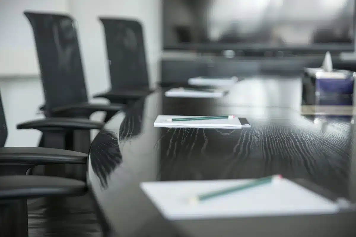 Scène de table d'écriture avec des notes et un ordinateur près d'une grande fenêtre