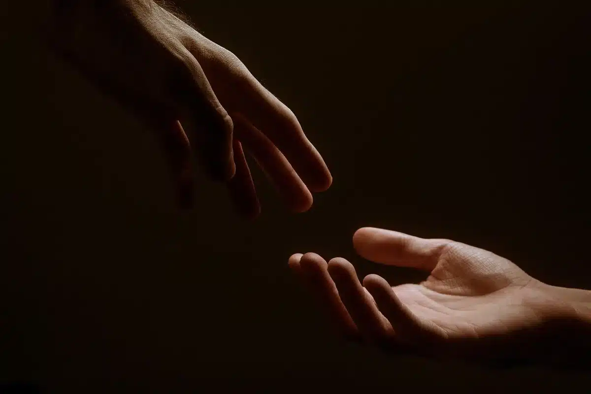 Parent posant la main sur l'épaule d'un enfant dans un salon lumineux