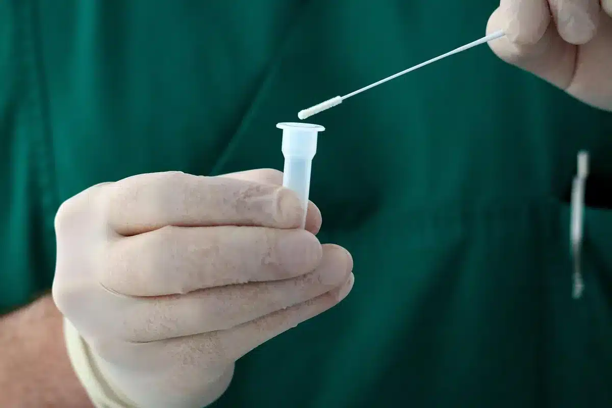 Tube à essai et petite seringue sur une table de laboratoire illustrant la production d'insuline