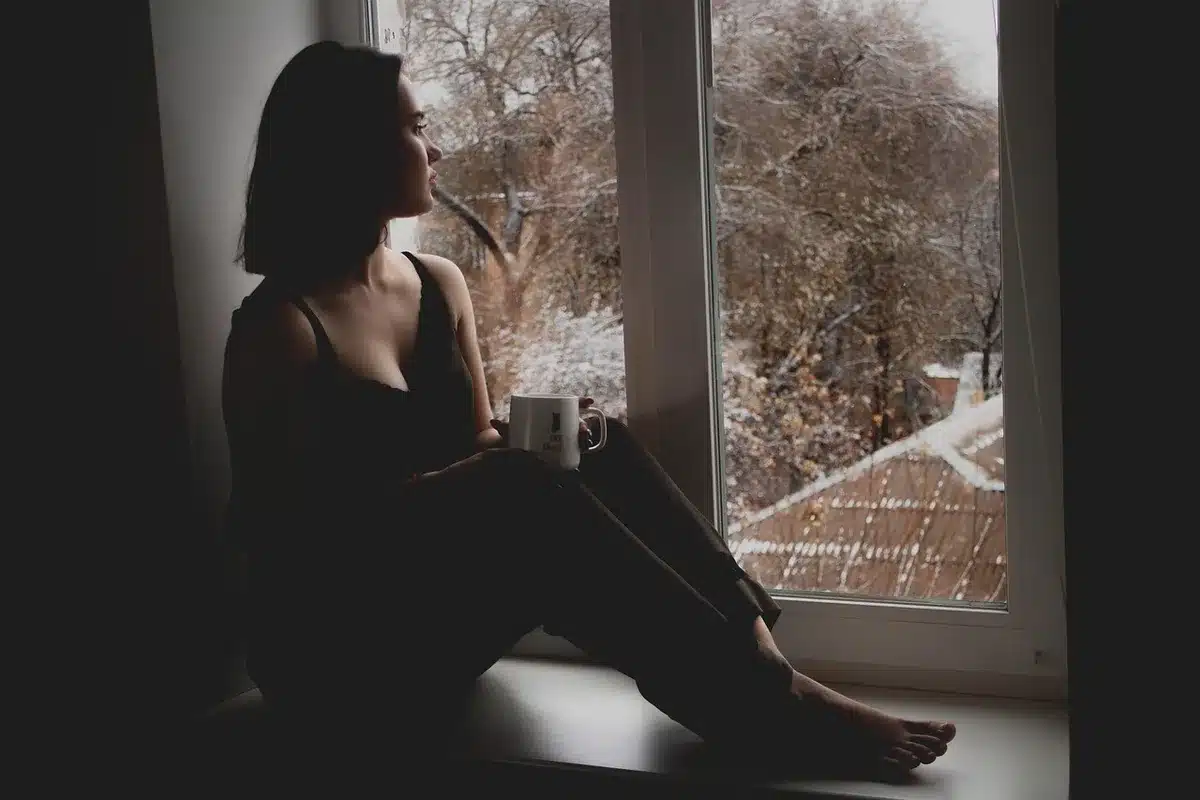Parent prenant une courte pause calme assis près d'une fenêtre en journée