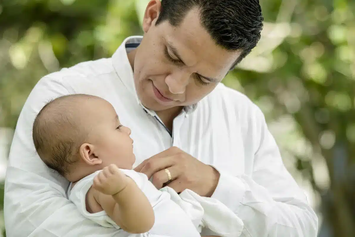 Parent assis proche d'un enfant sur un canapé lumineux, posture apaisée et présence attentive