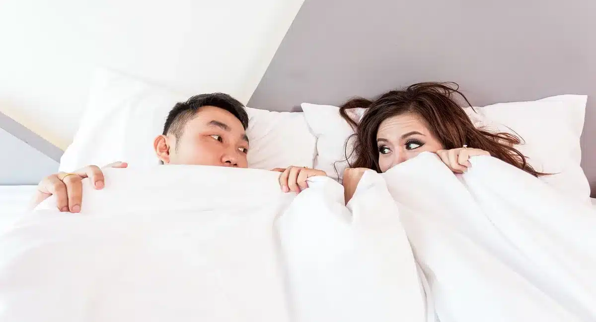 Chambre lumineuse avec fenêtre ouverte et ventilateur pour illustrer sommeil perturbé par la chaleur