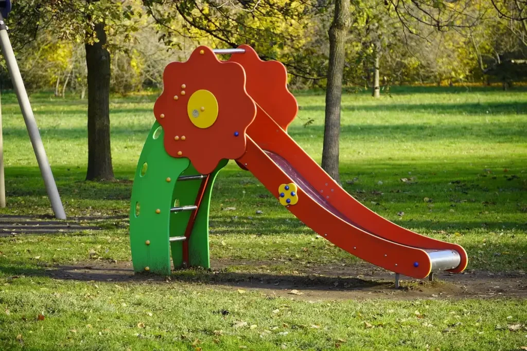 Mains couvrant une glissière de parc au soleil près d'une poussette à l'ombre